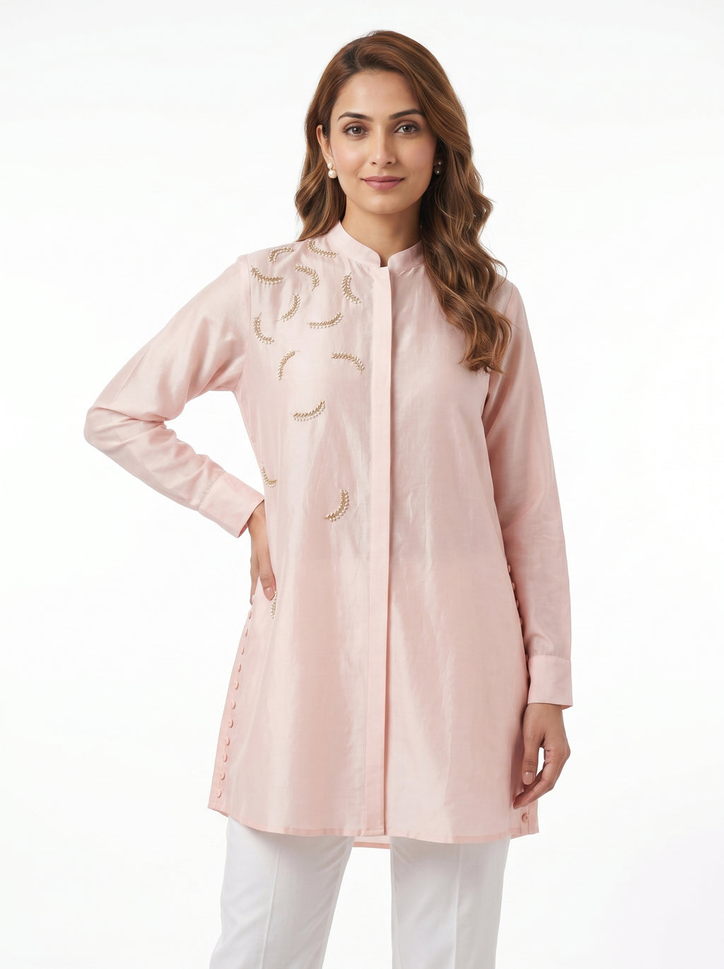 Woman wearing a light pink coat with floral embroidery on a white background